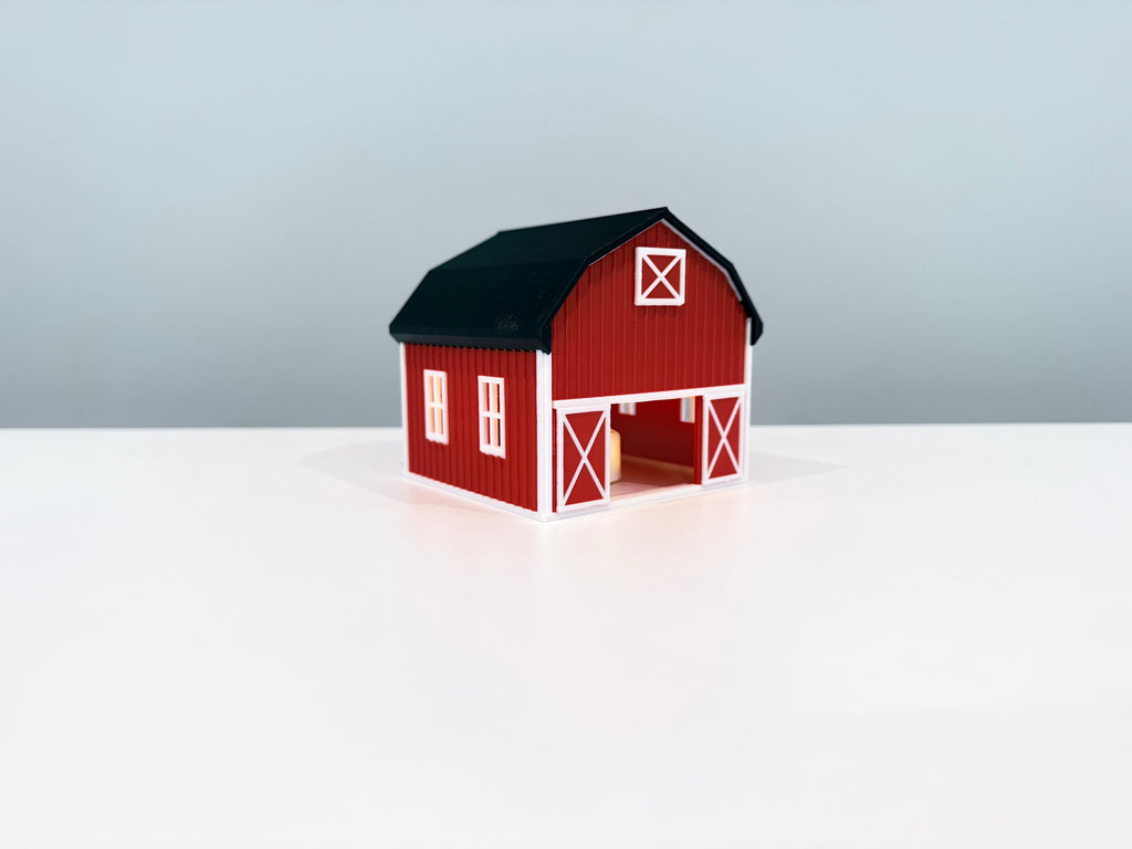 Red Barn miniature with a warm light visible inside the open doorway.