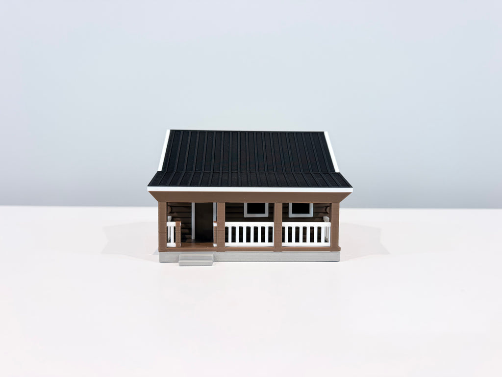 Front view of the Cabin miniature showing its covered porch, white railing and front steps.