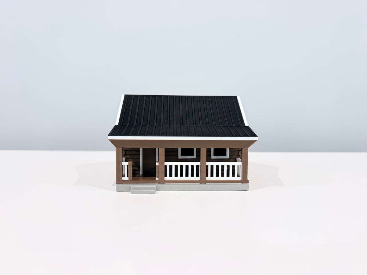 Front view of the Cabin miniature showing its covered porch, white railing and front steps.