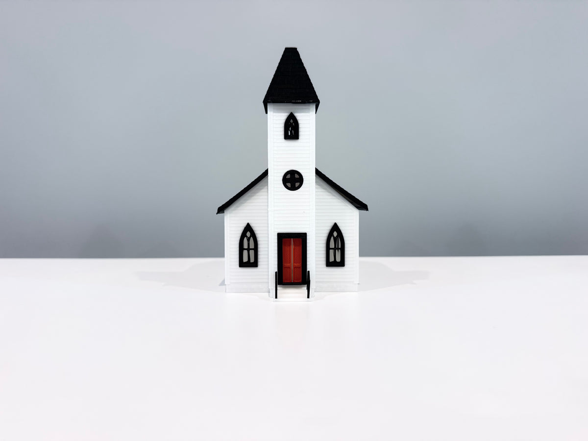 Front view of the Church miniature showing its spire, round window and red entrance door.