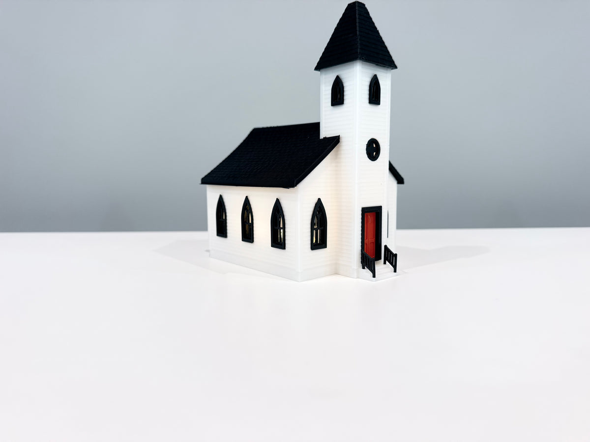 Church miniature with warm light visible through its windows.