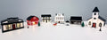 Primrose Christmas Village buildings and accessories arranged together on a white surface in daylight.