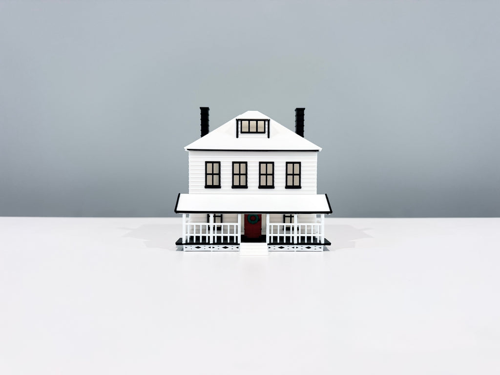 Front view of the Farmhouse miniature showing its windows, porch and two chimneys.