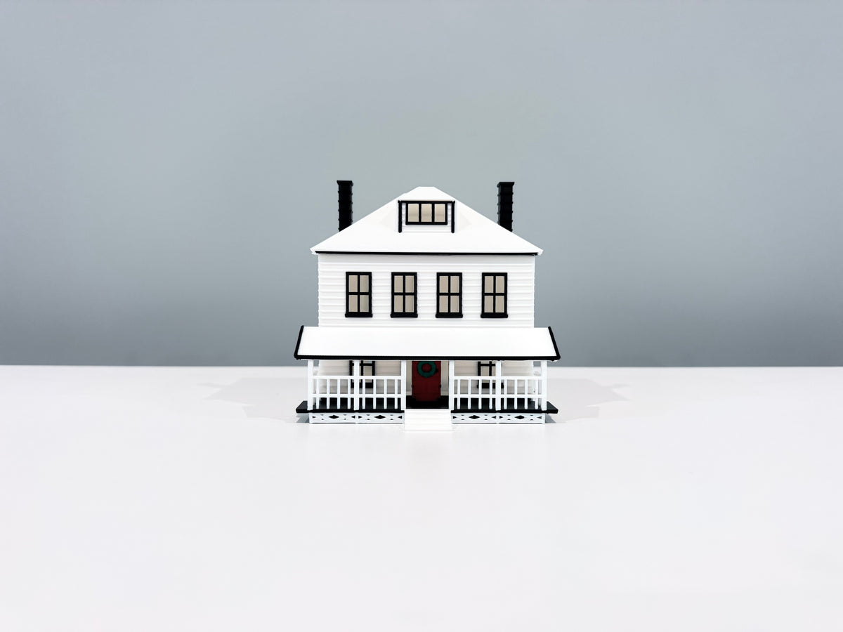 Front view of the Farmhouse miniature showing its windows, porch and two chimneys.