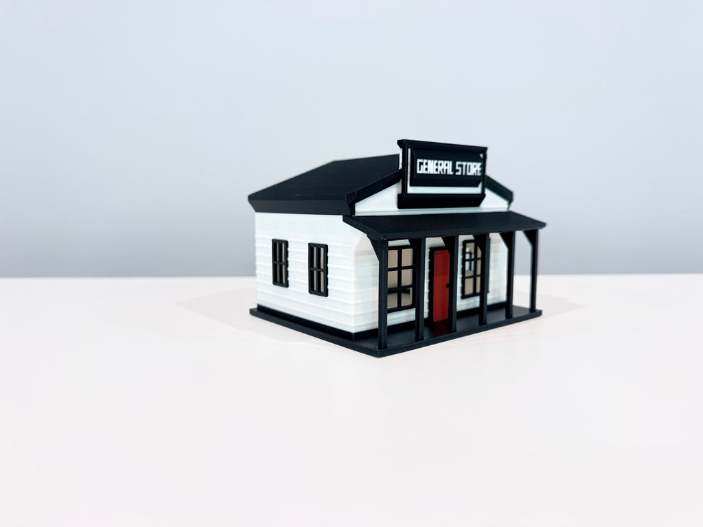 General Store miniature with white walls, black trim, a red door and a storefront sign, shown from an angle.