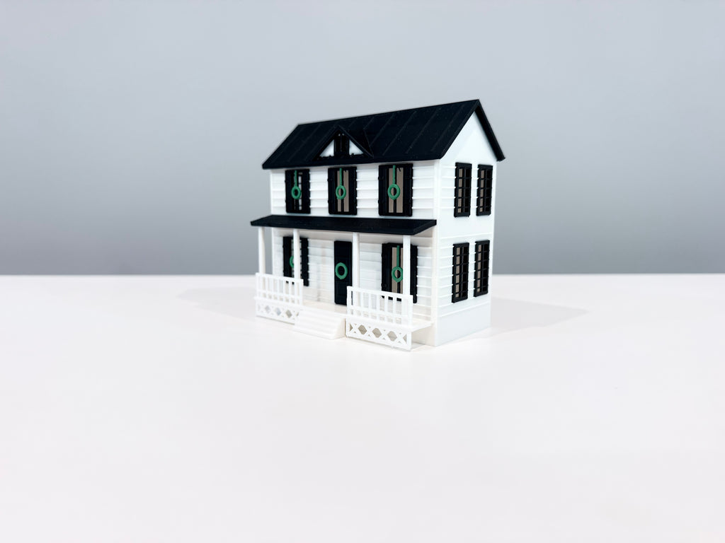 Opposite angled view of the Village House miniature showing its side wall and porch.