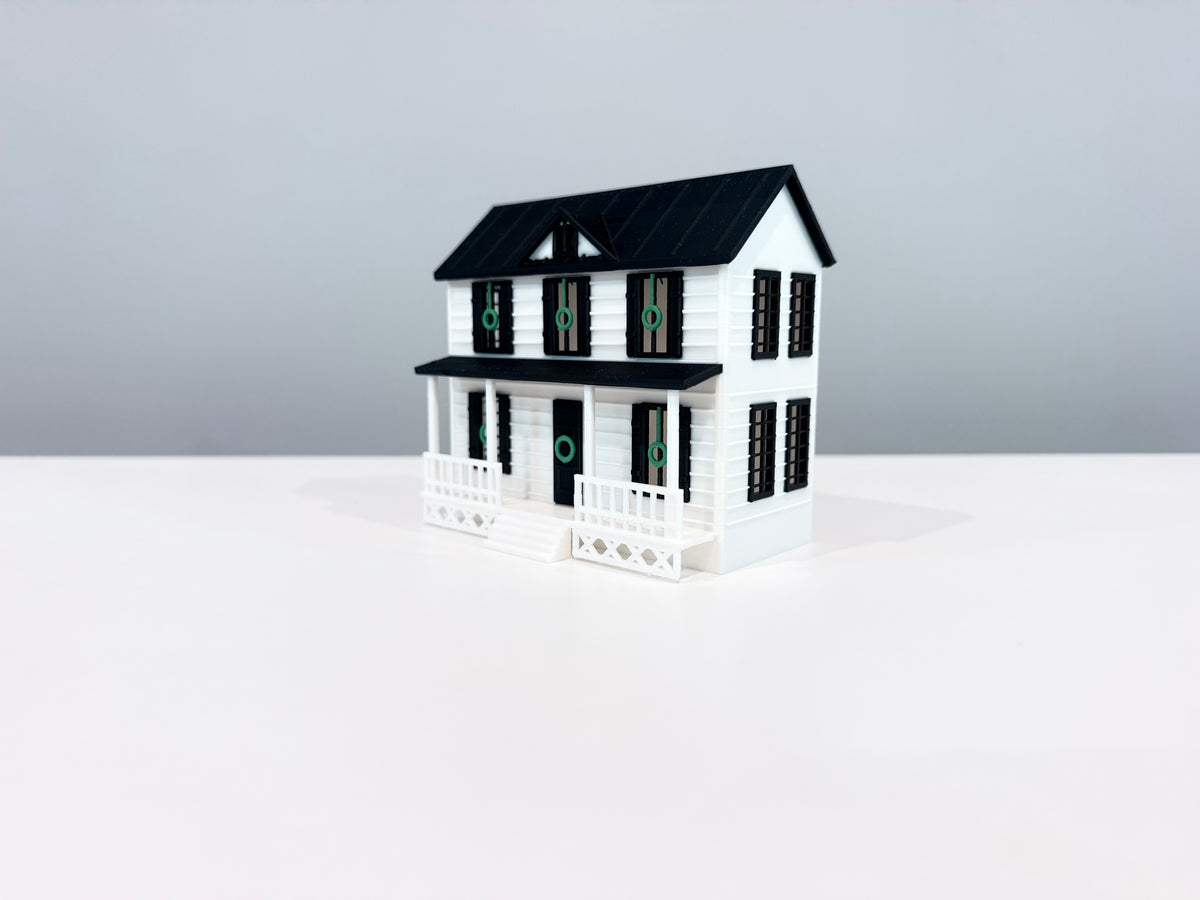 Opposite angled view of the Village House miniature showing its side wall and porch.