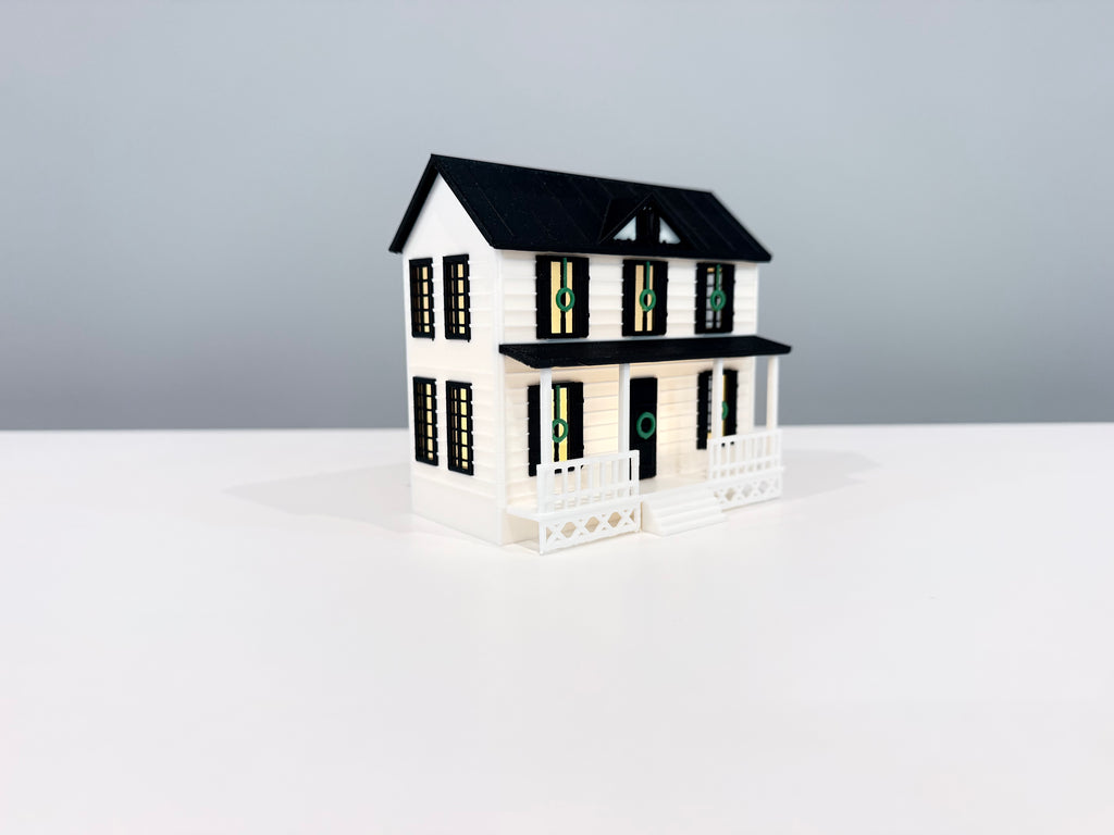Village House miniature with warm light visible through its windows.