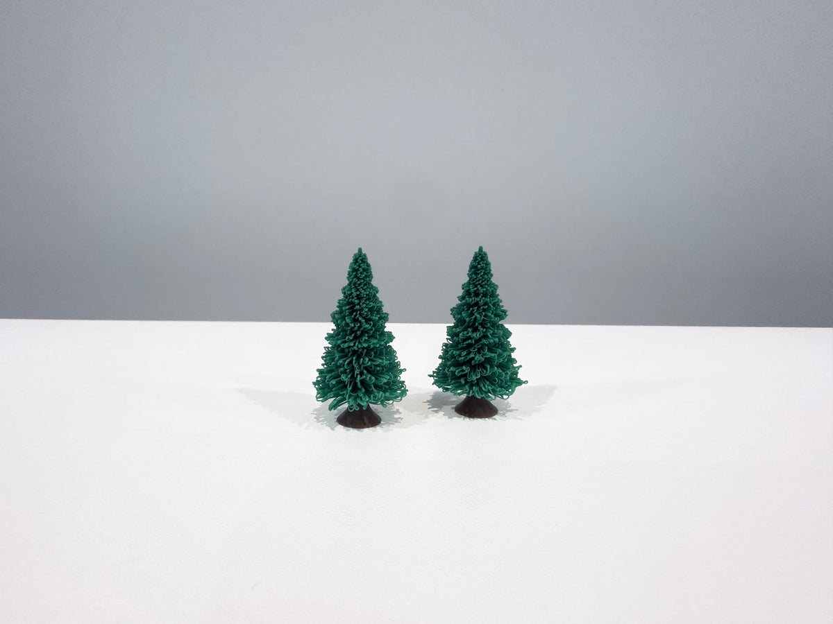 Two green miniature evergreen trees shown together on a white surface.